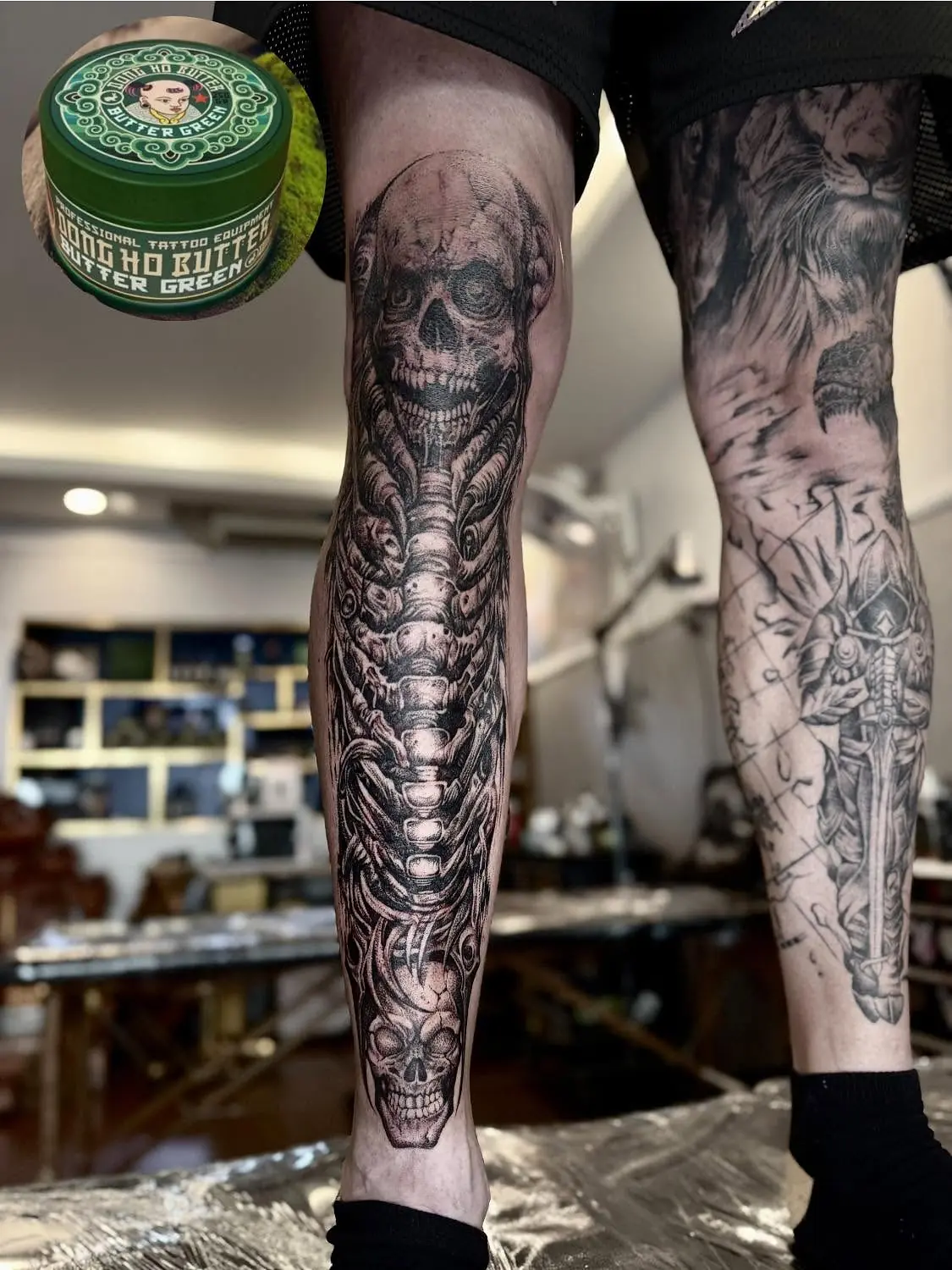 Skulls and biomechanical forms in black and grey down both lower legs