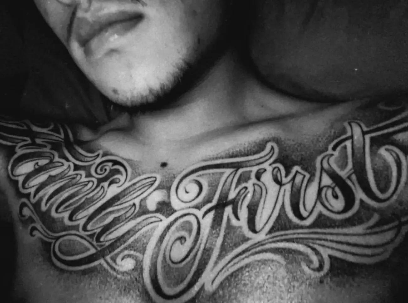 Family First in black and grey chicano script across a chest