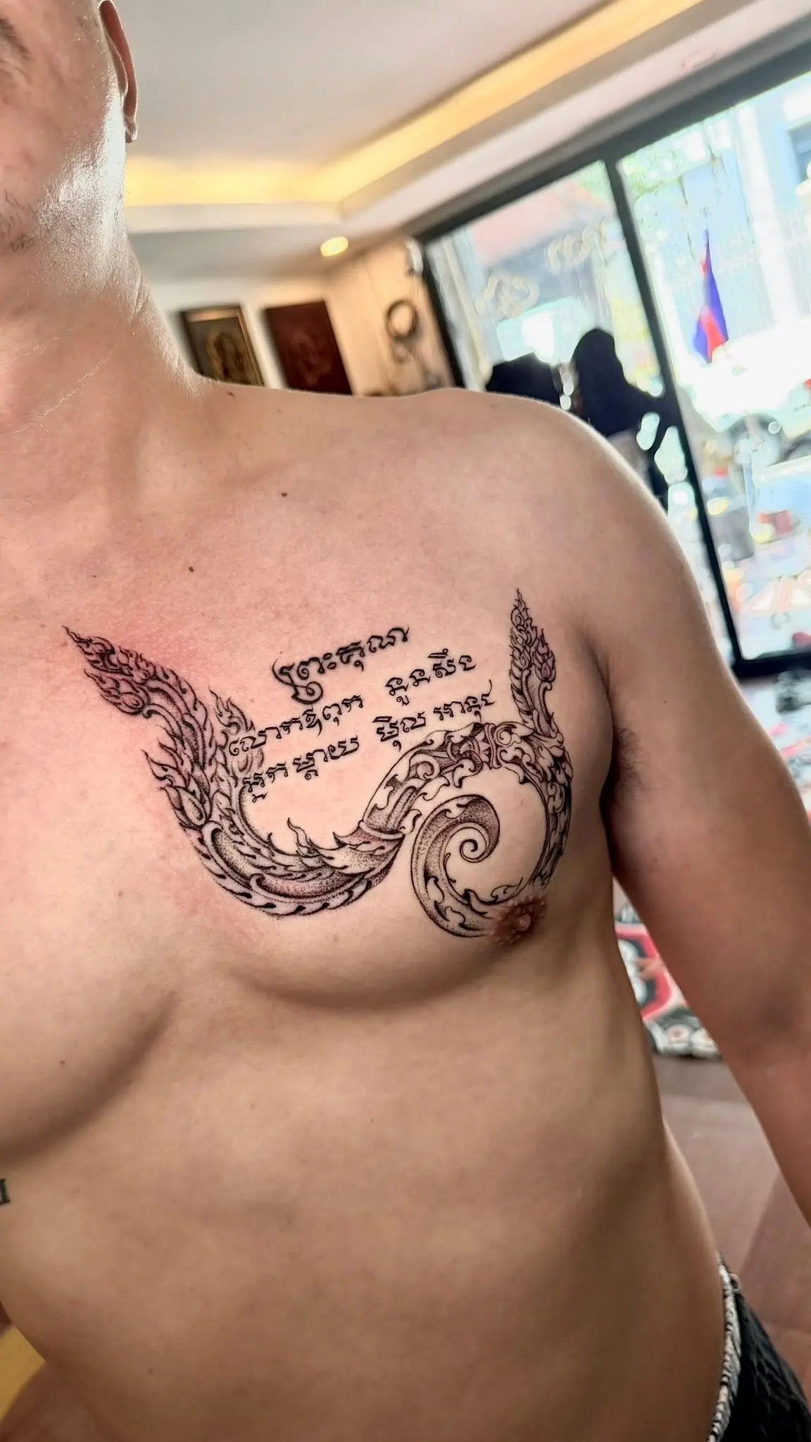 Khmer script with a traditional kbach curl across a chest