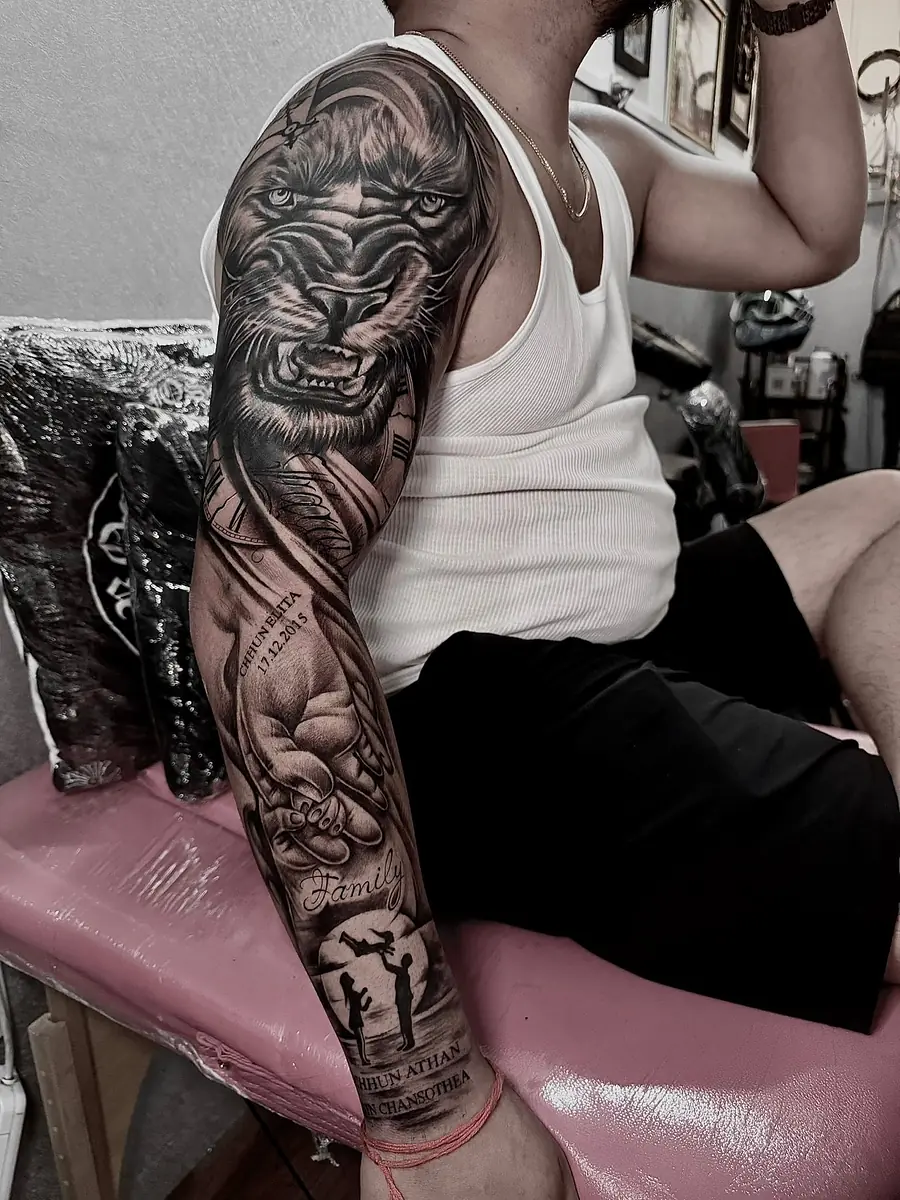 A lion in black and grey realism running down a full arm sleeve