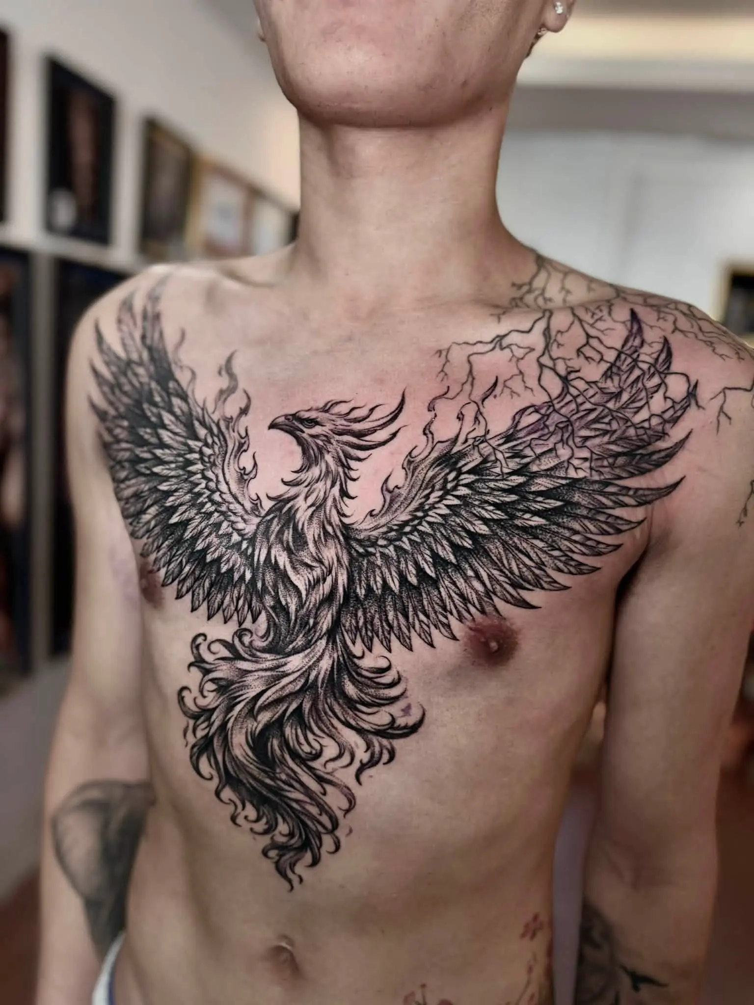 A fine blackwork phoenix with wings spread across a chest