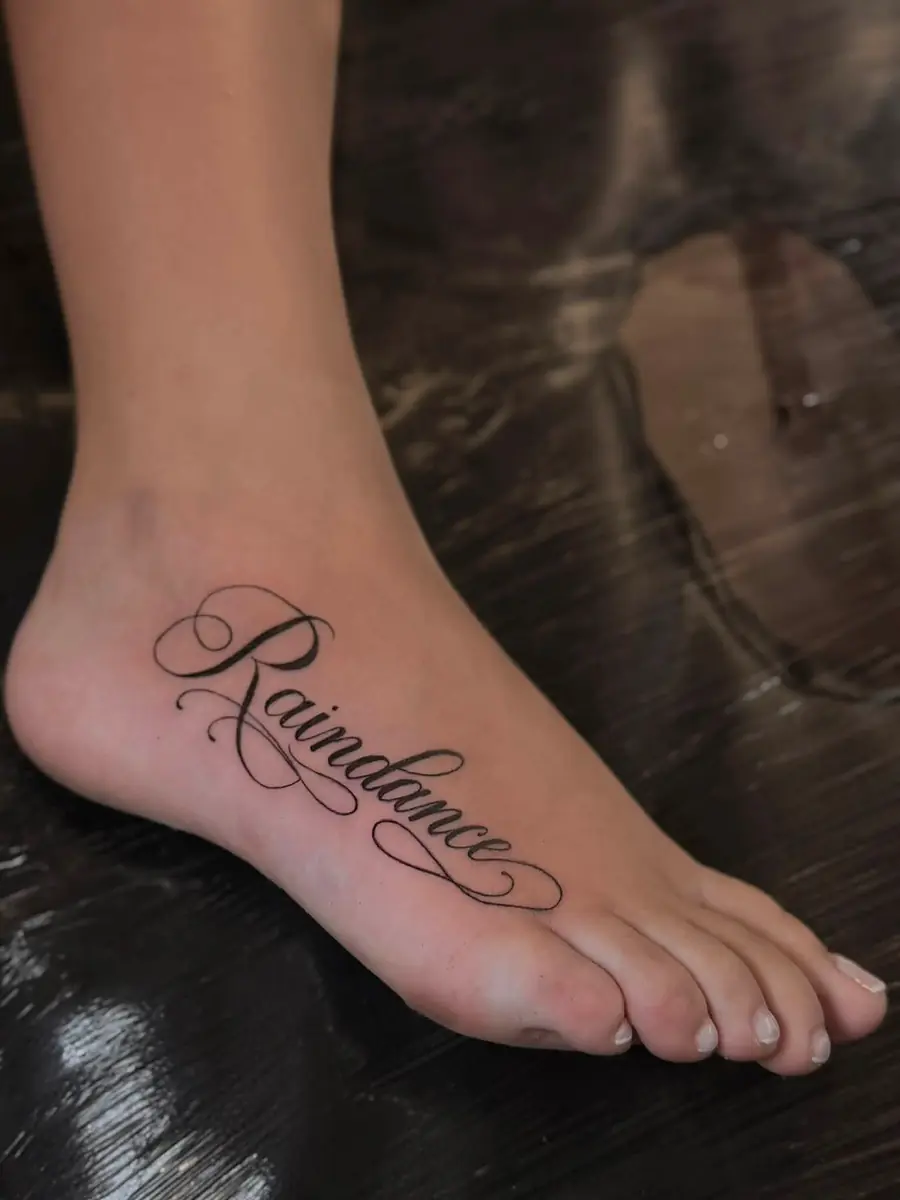 The word Raindance in fine script across the top of a foot
