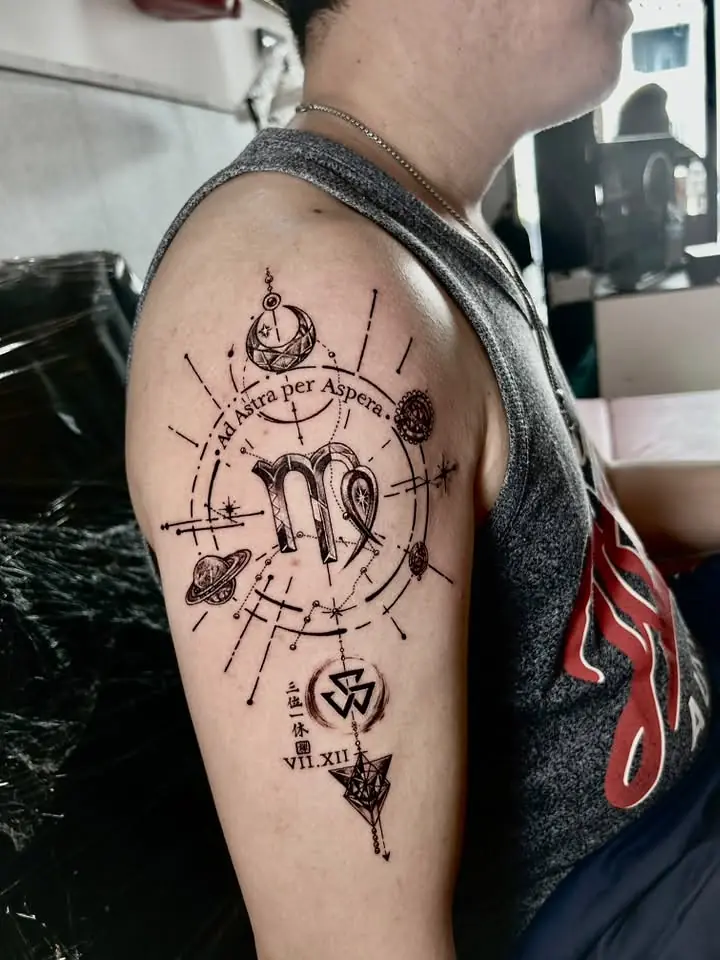 Fine line astrological symbols and planets across a shoulder